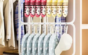 Close-up of white plastic drying rack with clips holding cute baby socks and hats