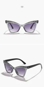 Detail view of girl's cat eye sunglasses with purple gradient lenses and rhinestones.