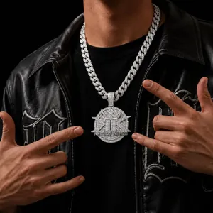 Close-up detail of iced out KING OF KINGS pendant on a cuban link chain