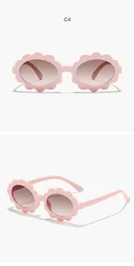 Detail view of kids flower-shaped sunglasses with pink frames and tinted lenses.