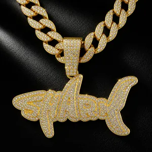 Detailed view of gold-plated hip-hop shark pendant with full CZ stones on Cuban chain.