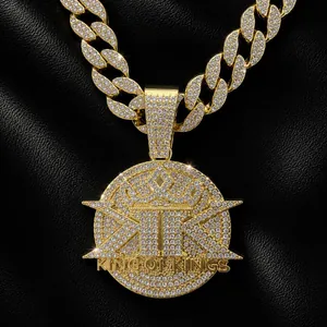 Detail shot of a gold-plated iced-out pendant with King of Kings engraving on black leather