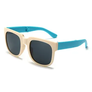 Close-up detail of stylish children's foldable sunglasses with beige and blue frame
