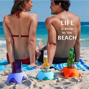 Colorful petal-shaped plastic beach cup holders for drinks and smartphones in use.