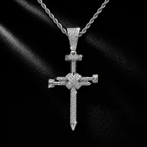Détail macro du pendentif croix à clous glacé avec zircons brillants sur chaîne corde