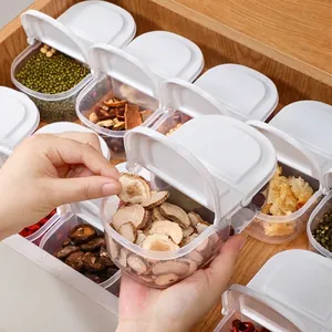 Set of stackable plastic spice storage containers with flip lids organized in a wooden drawer