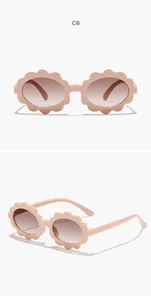 Close-up of cute peach flower-shaped children's sunglasses with gradient lenses
