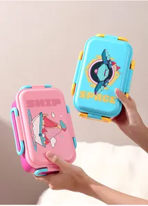 Nahaufnahme von rosa und blauen Brotdosen mit Cartoon-Motiven, die gehalten werden.