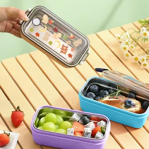 Cartoon 304 stainless steel lunch boxes for students shown on a wooden picnic table