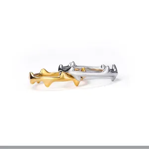 Detailaufnahme von Dornenringen aus Edelstahl in Gold und Silber mit poliertem Finish.