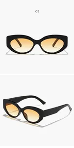 Dettaglio occhiali da sole cat-eye retrò con aste larghe e lenti sfumate ambra per donne.
