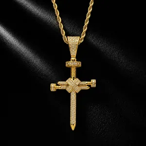 Vue détaillée d'un pendentif croix en clous dorés hip-hop serti de zircons brillants