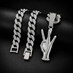 Imagen detallada de cadenas de eslabones cubanos con pedrería y un colgante de tres dedos.