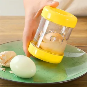 Handheld manual boiled egg peeler tool in yellow and transparent design for kitchen