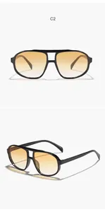 Detail view of retro oversized black aviator sunglasses with yellow gradient lenses.