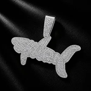 Detailed macro shot of iced-out shark pendant with crystals on black leather texture