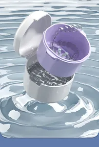 Detailweergave van de paarse reinigingsmand voor gebitsprothesen in helder water