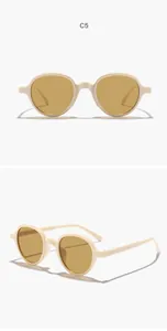 Detail view of stylish round cream sunglasses with tan lenses and light frame