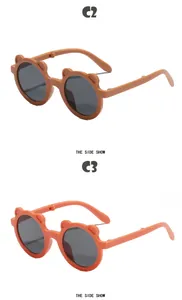 Detail view of cute foldable bear-eared sunglasses for kids in brown and coral.