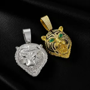 Detailaufnahme von Hip-Hop-Tigerkopf-Anhängern in Gold und Silber mit Smaragdaugen