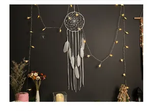 Handmade white Bohemian dreamcatcher with delicate feathers and ribbons for bedroom wall decor