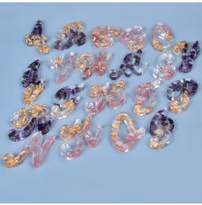 Close-up of resin alphabet letters with gold foil and purple amethyst stone fillings
