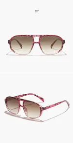Detail view of pink patterned oversized aviator sunglasses with a unique hollow double bridge