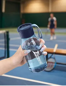 Gourde de sport bleue en plastique PCTG avec poignée dans un décor de court de tennis