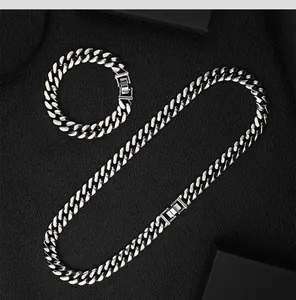 Vista dettagliata di un set di collana e bracciale a maglia cubana argento da 12 mm