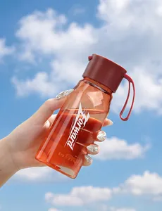 Gourde de sport d'extérieur en plastique PCTG tenue sur un fond de ciel bleu ensoleillé