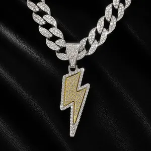 Close-up of iced out silver and gold lightning bolt pendant on cuban link chain jewelry