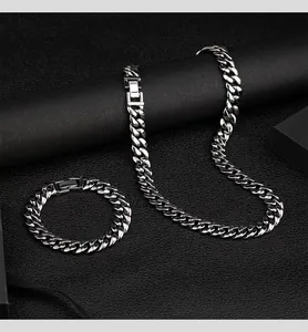 Vista dettagliata del set collana e bracciale a maglia cubana in argento lucido da 12 mm