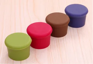 Vista dettagliata di tappi per vino in silicone colorato su fondo in legno chiaro