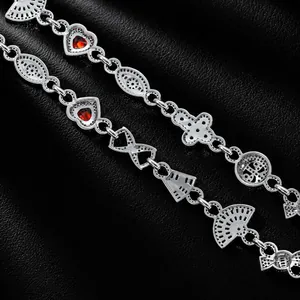 Detailansicht versilberter Hip-Hop-Armbänder mit rotem Herzzirkon und Fächer-Anhängern.