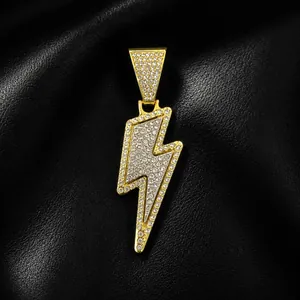 Macro view of an iced out lightning bolt pendant featuring pavé-set sparkling crystals on gold