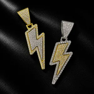 Close-up of gold and silver hip hop lightning bolt pendants with iced out rhinestones