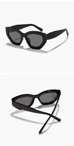 Vue détaillée de lunettes de soleil œil-de-chat noires irrégulières avec monture brillante.