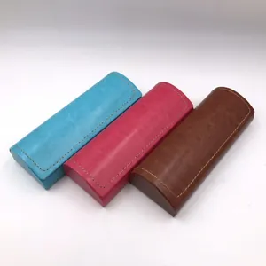 Detailed view of three PU leather glasses cases in blue, pink, and brown.
