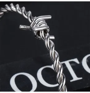 Macro detail of men's titanium steel barbed wire bracelet in silver hip-hop style