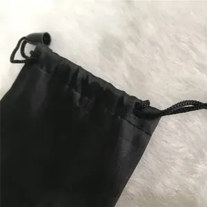 Macro detail view of black fiber drawstring pouch showing fabric texture and cord