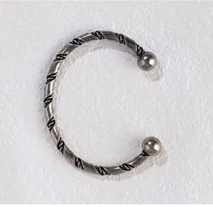 Nahaufnahme der aufwendigen gedrehten Textur eines silberfarbenen Vintage-Manschettenarmbands