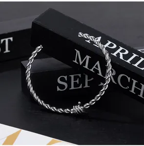 Close-up of minimalist twisted stainless steel cuff bracelet with barbed wire detail