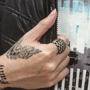 Anillo vintage plateado con textura de ladrillo para hombre y mujer en mano de modelo tatuada