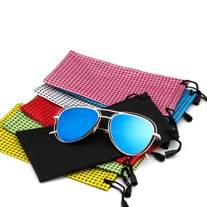 Primo piano di borse per occhiali in nylon a scacchi con occhiali da sole a specchio blu
