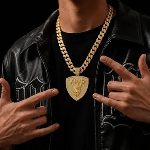 Detailed shot of a men's iced out lion head pendant on a gold Cuban link chain.