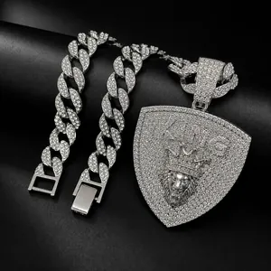 Detailed view of silver iced out Cuban chain with lion head KING shield pendant