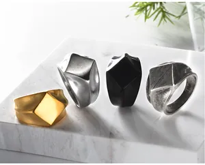 Detailansicht von vier geometrisch facettierten Ringen in Gold, Silber, Schwarz und Antik.