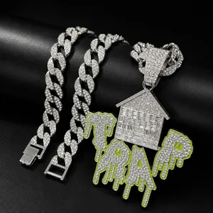 Detail view of iced-out house pendant with green TRAP drip on silver Cuban chain.