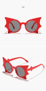Detailansicht der roten fledermausförmigen Kindersonnenbrille mit grauen runden Gläsern