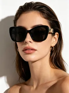 Close-up of elegant black cat-eye sunglasses with gold temple detail on a female model